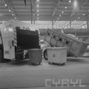 śmieciarki i kontenery do śmieci w hali wystawowej