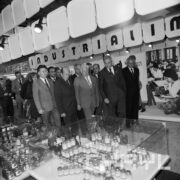 grupa mężczyzn w hali wystawowej, na pierwszym planie szklane gabloty ze słoikami