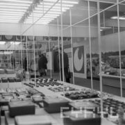 stoiska w hali wystawowej, między nimi zwiedzający ludzie