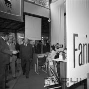 grupa mężczyzn ogląda stoiska w hali wystawienniczej