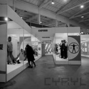 stoiska wystawowe z manekinami w strojach roboczych, przed stoiskiem z lewej dwie osoby zwiedzające