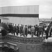 duża grupa ludzi, w większości mężczyzn, na terenie wystawowym