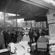 grupa mężczyzn i jedna kobieta w hali wystawienniczej