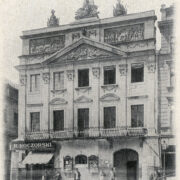 kilkukondygnacyjna kamienica z oknami, balkonami i ozdobną fasadą