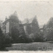 duży budynek z cegieł, wokół bujne drzewa